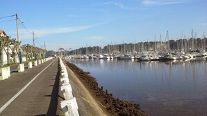 A marina with numerous boats docked along a paved walkway. - fully equipped apartment on the first floor (capbreton)