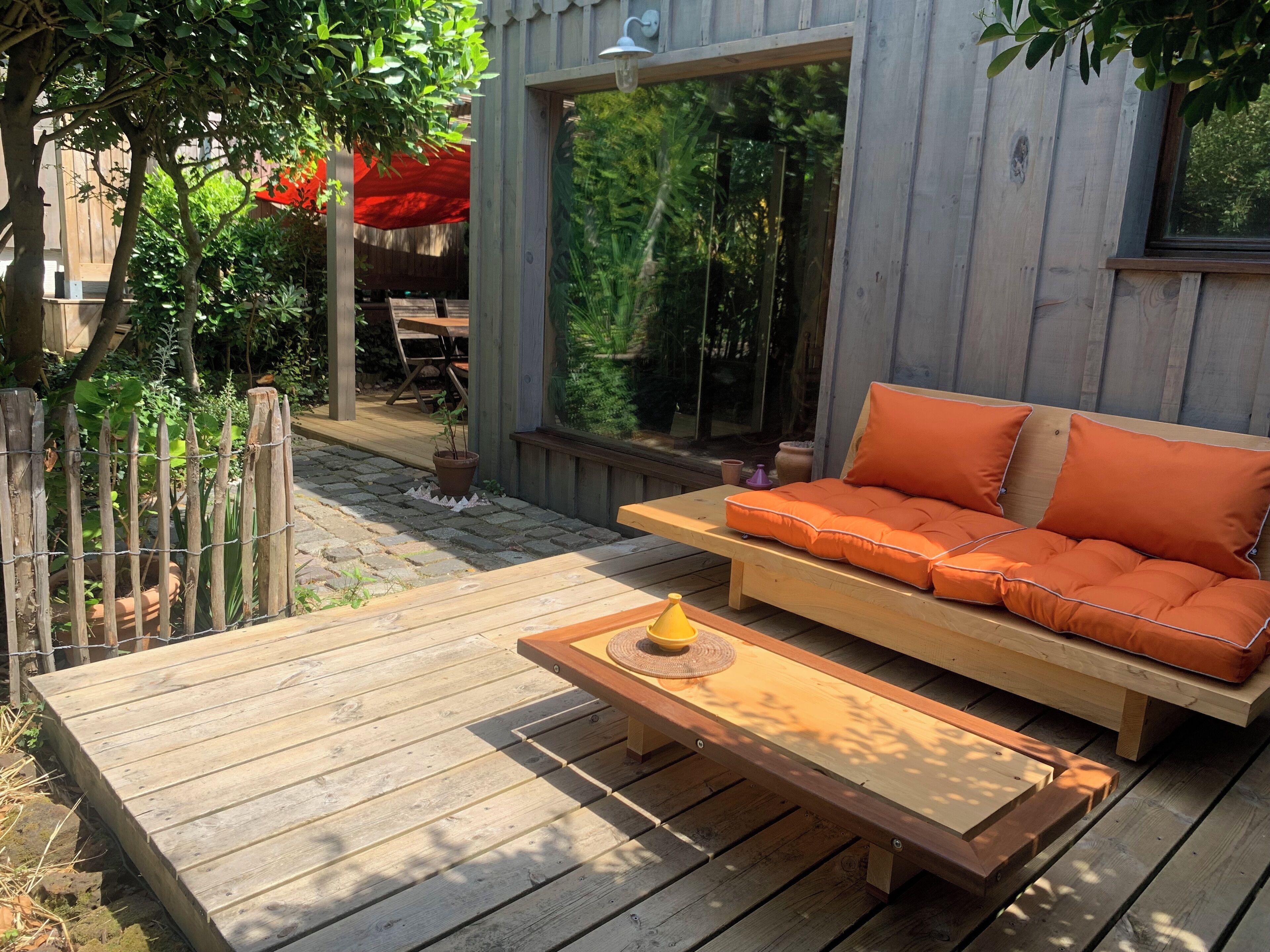 Une terrasse en bois avec un canapé et une petite table.