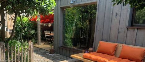 A wooden deck with a sofa and a small table.