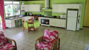 A compact kitchen with a dining area, including a table and chairs, a stove, and a refrigerator.