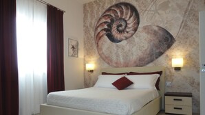 A hotel room with a large bed, two bedside tables, a wall mural, and a window with curtains. - Sea Front Villa with Private Pool - Free WiFi (Santa Maria di Leuca)