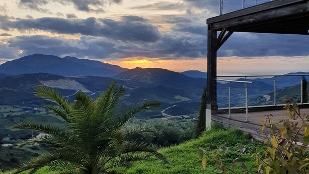 Una vista panoramica da un punto elevato su una valle con montagne sullo sfondo.