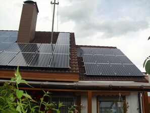 A house with solar panels on the roof and a satellite dish.