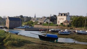 A riverside view with boats docked along the shore, a bridge, and buildings in the background. - Apartment 1ST Floor, SEA View (Paimpol)