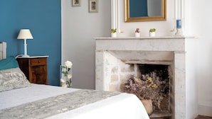 A bedroom with a bed, a nightstand, a lamp, a fireplace, and framed pictures on the wall. - MAS OF VILLAGE IN JONQUERETTES NEAR AVIGNON (Jonquerettes)