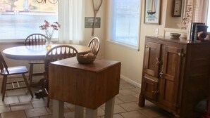 A dining area with a round table, chairs, a wooden cabinet, and a ceiling fan. - 'The Captain's Cottage' on Lake Hamilton (Hot Springs)