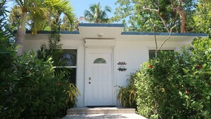 A white building with a door and a sign that reads "Keys Cottage." - Keys Kottage & Bayside Villa W/ free onsite boat ramp marina & trailer parking. (Islamorada)