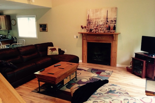 Open floor plan living room with gas fireplace, beautiful views and deck access