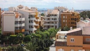 Un quartier résidentiel avec des immeubles à plusieurs étages, des balcons et un ciel dégagé.
