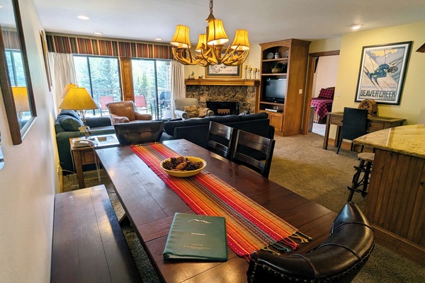 Living room with wood fireplace, dining table, and balcony w/ propane BBQ grill