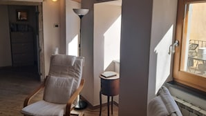 A room with a wooden chair, a small table with a book, a floor lamp, and a window with a view. - La Terrazza sulla Valle, with private terrace overlooking the valley! (Cortona)