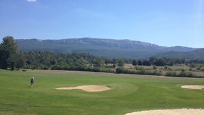 Un campo da golf con vista chiara sulle montagne sullo sfondo.