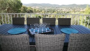 Una mesa dispuesta con cristalería y vistas a un paisaje montañoso.