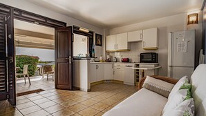 Cocina compacta con refrigerador, microondas y un pequeño comedor.