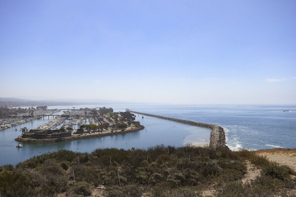 A coastal marina with boats, a pier, and a lighthouse. - Blue Tide Cottage: Ocean Views, Steps to the Beach, Dining, Shopping + More! (Dana Point)