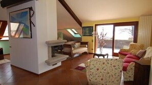 A spacious living room with a fireplace, a sofa set, and a dining area.