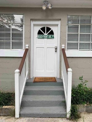 A front door with a nameplate reading 'BEACH FRONT AVE.' and a welcome mat. - Executive Emory studio, sleeps 2 (Atlanta)