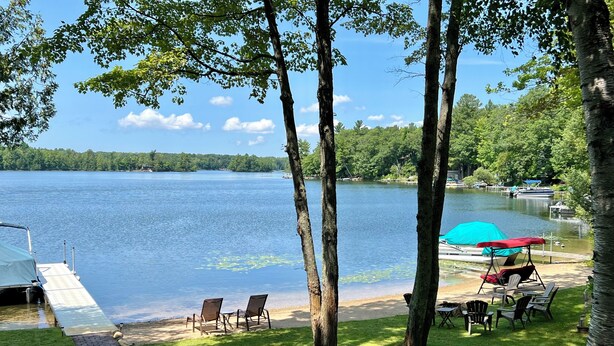 Une terrasse au bord du lac offrant une vue sur le lac, avec un quai et un bateau.