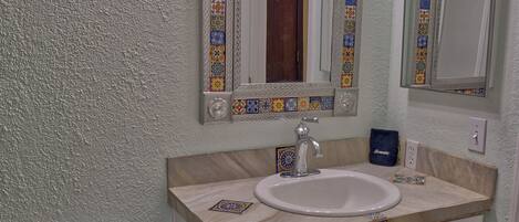 A bathroom with a toilet, sink, and mirror.