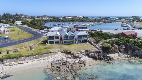 A coastal property with a marina, modern buildings, and a rocky shoreline.