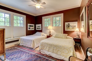 A bedroom with two beds, a ceiling fan, and large windows. - Waterfront House in the center of the village (Douglas)