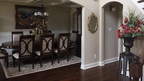 A dining area with a wooden table and chairs, a chandelier, and a painting above. - New Listing! Fully furnished! Available for Master's!! (Augusta)