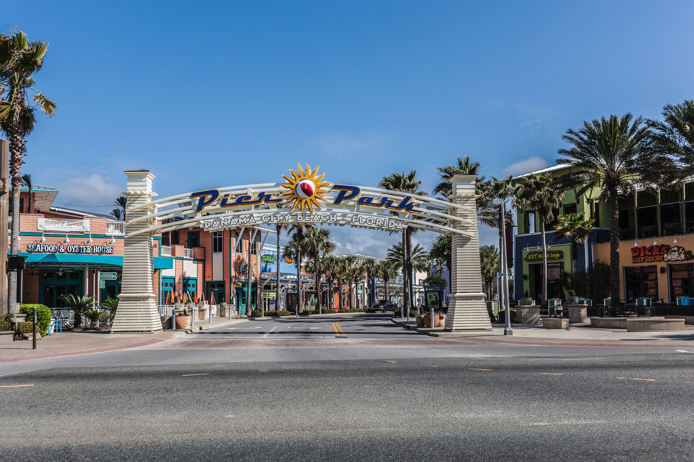 Une vue de rue avec une enseigne bien visible indiquant « Panama City Beach, Floride » et un restaurant appelé « Seafood & Oyster House ».