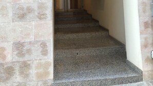 A staircase leading to a room with a number 7 sign, a door, and a wall-mounted shelf with boxes. - COZY APARTMENT 50 M FROM THE BEACH with WIFI (L'Ampolla)