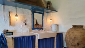 Une salle de bain avec un double vasque, un miroir, une lanterne et un grand vase.
