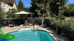 A swimming pool with clear water, surrounded by a garden and a house. - 
Gite with pool & fab gardens 5 mins from quaint village with restaurants & shop (Trémolat)