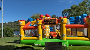 A colorful inflatable play structure with a sign that reads 'Le Chateau Fort.'