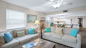 Ein Wohnzimmer mit zwei Sofas, einem Couchtisch und einem Deckenventilator.