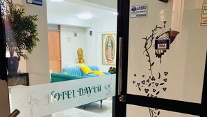 A hotel entrance with a glass door, a sign indicating a maximum capacity of 100 people, and a 'VISA' sign on the wall. - Hotel Daylu Cusco (Cusco)