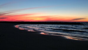 A beach at sunset with waves and a clear sky. - Sweet  Victorian Beach Cottage (Cape Charles)