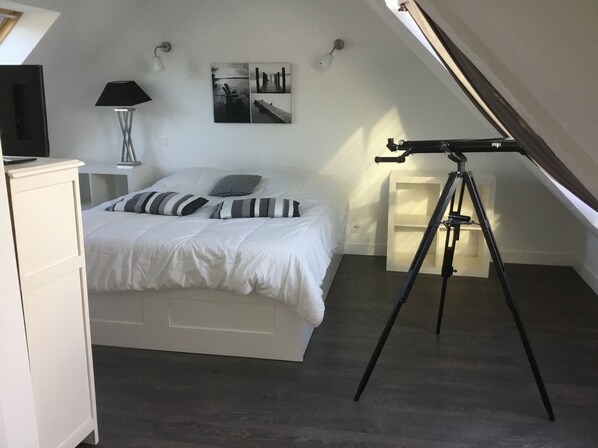 A bedroom with a bed, a desk, a lamp, a telescope, and a wall-mounted picture. - House with shared pool 3.5 km from the beach (Guérande)