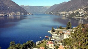 A lake surrounded by mountains with a small town and buildings along the shore. - Cà Elsa B&B (Nuova Olonio)