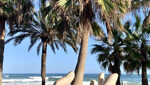 A sculpture of reclining figures in a park with palm trees and a view of the ocean. - Ref: 255 Fully renovated 1-bedroom apartment with sea views in the heart of Los Boliches, Fuengirola, ideally located just one row back from the beach (Fuengirola)