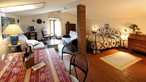 A cozy living room with a dining area, a television, and a fireplace. - Studio with private balcony, great views, wifi, shared pool, close to village (Vinci, Florence)