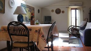 A dining area with a table, chairs, and a television. - Studio with private balcony, great views, wifi, shared pool, close to village (Vinci, Florence)