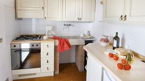 A compact kitchen with white cabinets, a gas stove, a sink, and a small refrigerator. - Studio with private balcony, great views, wifi, shared pool, close to village (Vinci, Florence)