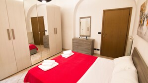 A hotel room with a large bed, a dresser, a mirror, and a wardrobe. - Cozy apartment in the historic heart of Piombino (Piombino)