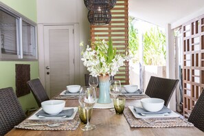 Enjoy meals in this dining area with a wooden table, comfortable chairs, and a beautiful centerpiece.