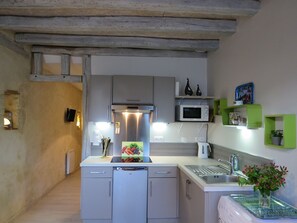 Enjoy cooking in this well-equipped kitchen with a stainless steel refrigerator, microwave, and modern sink.