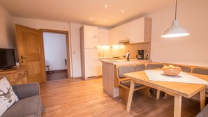 Eine moderne Küche mit weißen Schränken, einem Holztisch und einer fest eingebauten Sitzbank.