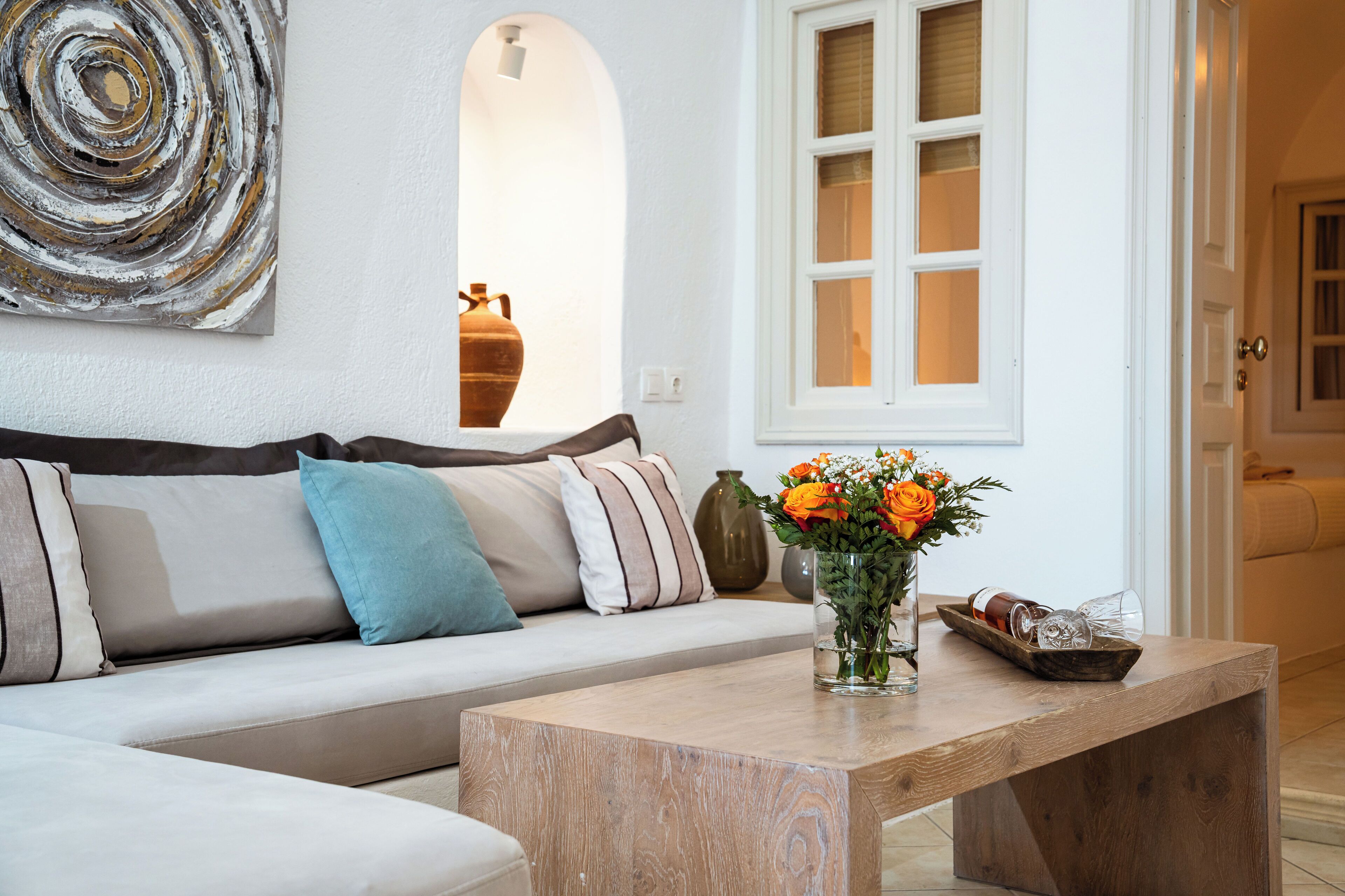 Uma sala de estar moderna com um sofá, uma mesa de centro e um vaso com flores.