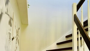 Eine Treppe mit weißen Wänden und dunklen Holzhäuschen.