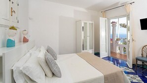 Une chambre à coucher avec un lit, une armoire et un balcon offrant une vue.