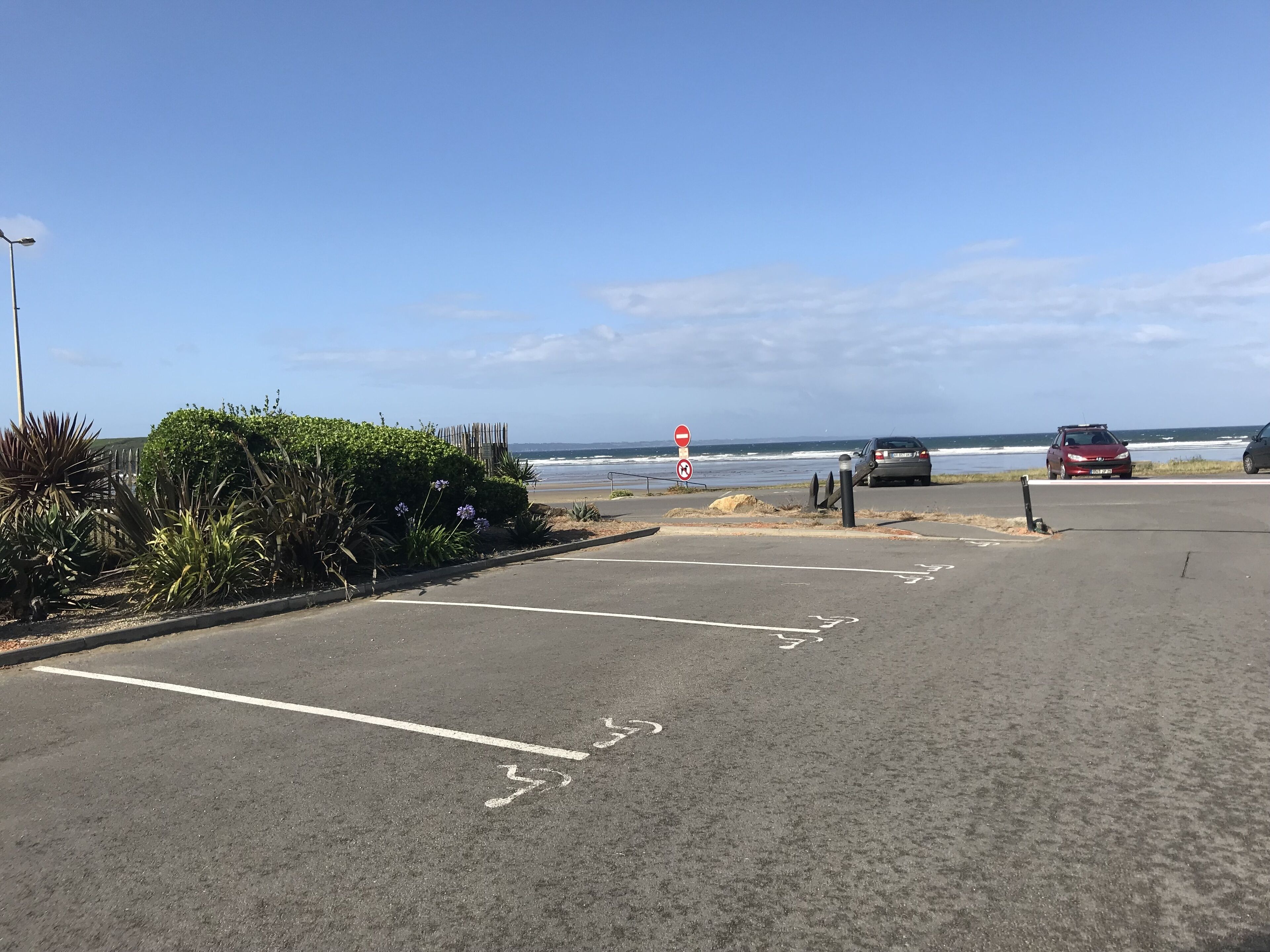 Ein Parkplatz mit Blick auf Strand und Meer.