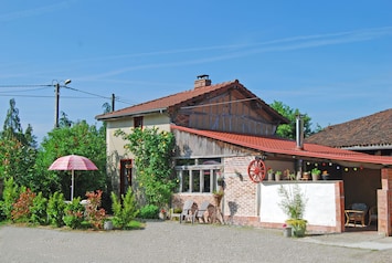 Vue de la façade (cÎté EST) avec la terrasse extérieure et le patio couvert