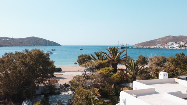 Blick auf die Küste mit Booten, einem Strand und Gebäuden.